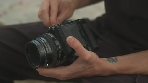 Hands Adjusting a Vintage Film Camera