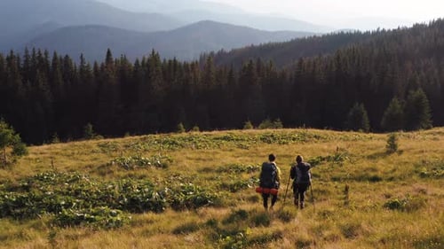 Couple of tourists walks up on hill. Majestic Carpathian Mountains. Beautiful landscape of untouched