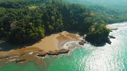 Aerial view of a secluded rainforest bay in Costa Rica in dry season on sunny day