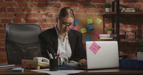 Young Businesswoman in Office with Brick Wall Background