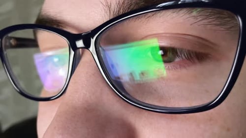 Nahaufnahme eines müden Mannes, der nachts am Laptop arbeitet, Mann mit Brille mit Reflexionen und Überlastung