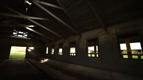 Interior pan from left to right of an abandonded barn near an insane asylum, dark, creepy, condemned