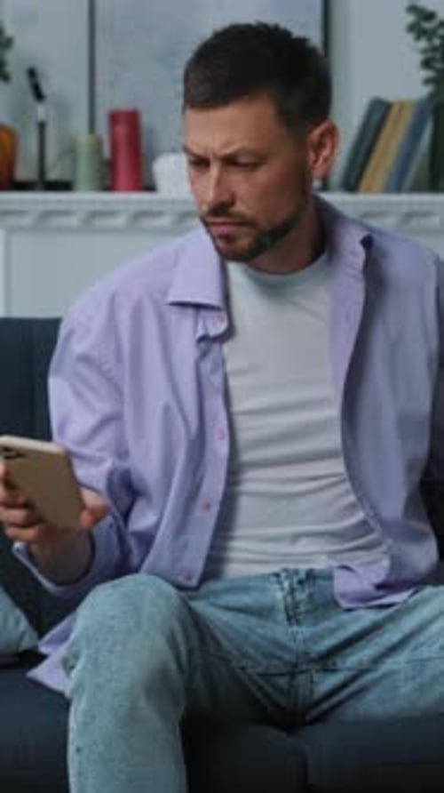 A Thoughtful Man Reads a Book in His Cozy Living Room Creating a Calm Content Atmosphere