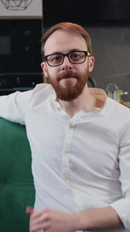 Man Gives Thumbs Up Indoors on Green Couch