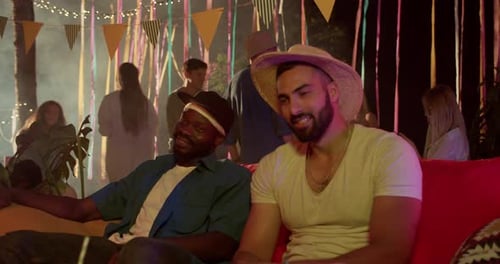 Jovens engraçados, amigos, olham em volta, conversam, conversam, curtem, relaxam na festa noturna, sorriem, felizes