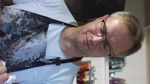 Artist Holding Paintbrushes in Art Studio