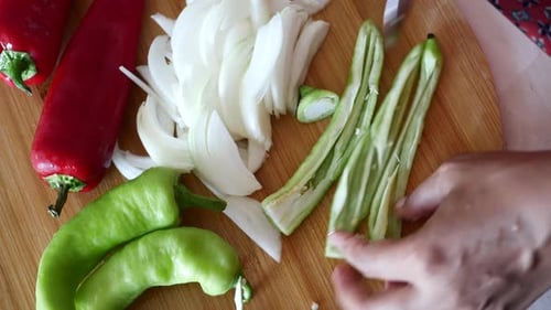 Slicing Green Pepper with Onions and Red Peppers