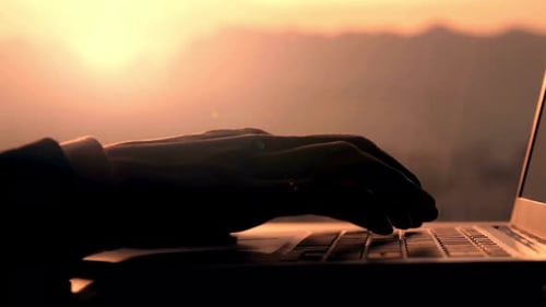 Hands Typing on Laptop at Sunset, Golden Hour Light