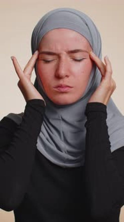 Woman Wearing Hijab With Headache Massaging Temples Close Up