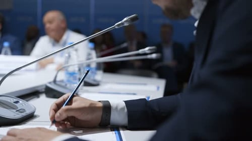 Gruppe junger Politiker sitzt am Tisch bei einem Informationsvortrag zum Brainstorming von