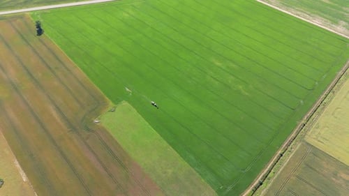 Top-down shot of a farmer working on a field in a tractor