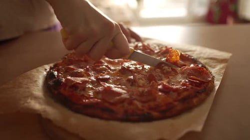 Woman Cutting Freshly Baked Pepperoni Pizza