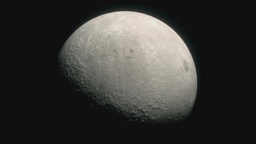In the darkness of outer space the crater covered surface of the Moon can be seen slowly rotating