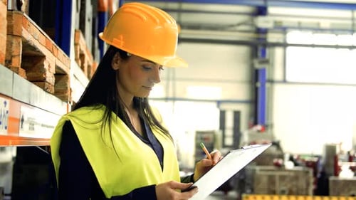 An Industrial Woman Engineer in a Factory Checking Documents
