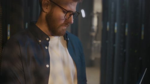 Young Male IT Specialist Analyzing Mainframe Work in Data Center