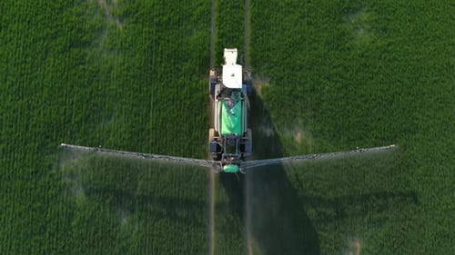 Farming Tractor Crop Sprayer on Green Field