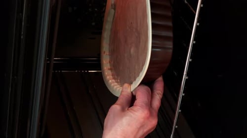 Geben Sie frischen rohen Teig von Hand in die Backform und in den Elektroofen