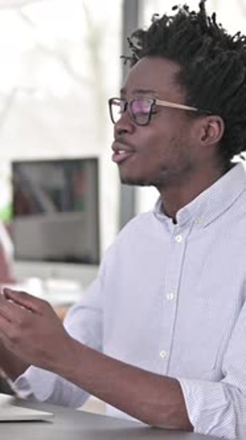 Man Video Conferencing at Desk in Modern Workplace