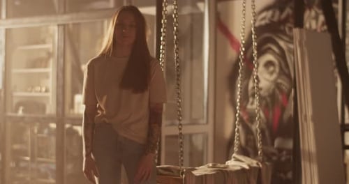 Woman Standing in Warmly Lit Room with Chain Swing