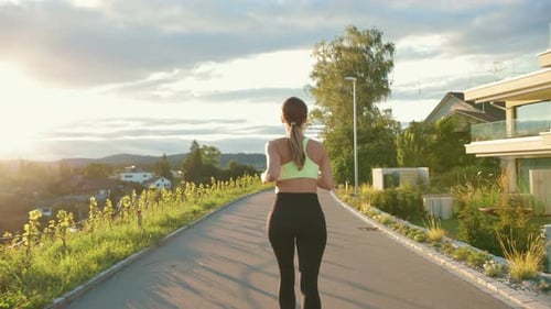 Back View of the Caucasian Young Woman Athlete Running on Street Outside the City Alone Pretty Happy