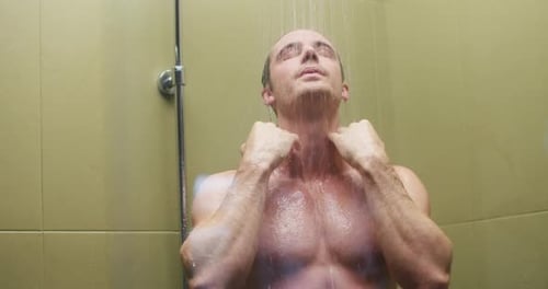 Young Man Washes Out Shampoo From Black Hair in Hotel Shower