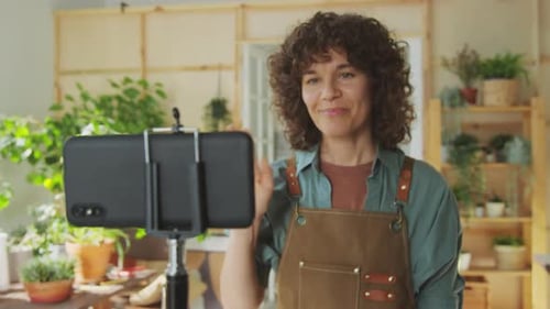 Woman Filming Plant Tutorial on Smartphone