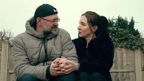 Affectionate Couple Holding Hands, Sitting on Rural Bench