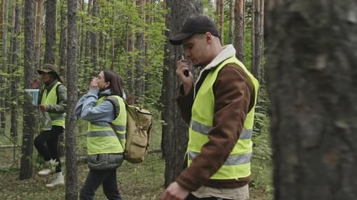 People Explore Forest Using Map and Radio