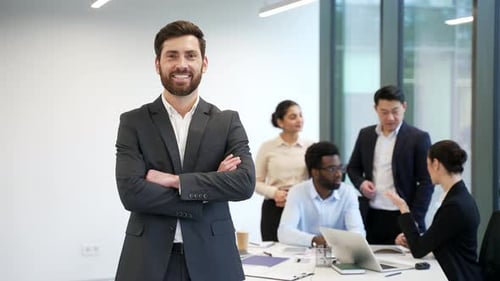 Portrait a businessman leader on background diverse team employees in office. Handsome bearded