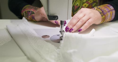 Woman Sewing White Fabric with Sewing Machine Close-up