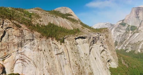 Amazing grey steep cliffs in Yosemite National Park, USA. Pine trees growing at the rocks