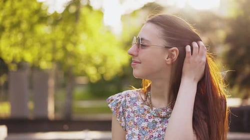 Retrato de uma jovem mulher no parque ao pôr do sol