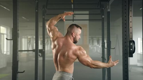 Muscular Man Flexing at a Gym