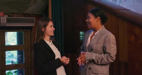 Two Businesswomen Confidently Discussing Strategy in an Office
