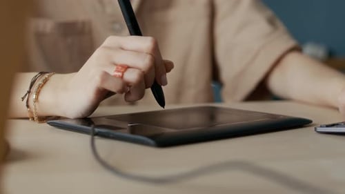 Digital Artist Uses Tablet and Stylus at Desk