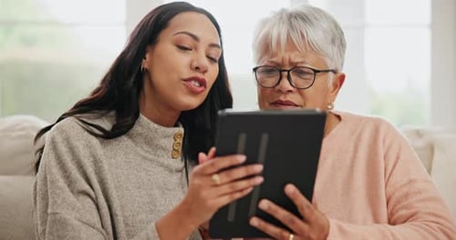 Grandmother and Adult Daughter Use Tablet Together