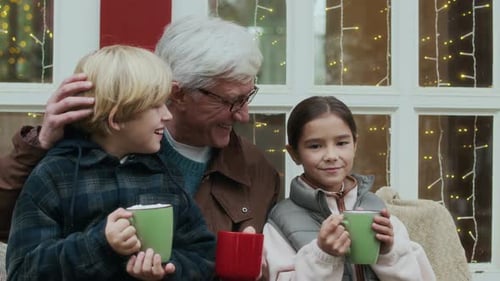 Grandfather with Grandchildren Enjoying Winter Holiday Drink