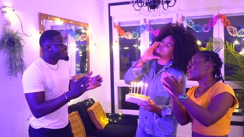 Friends Celebrate Birthday with Cake Indoors at Night