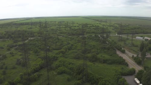 Aerial view of high-voltage electrical substation and surrounding landscape