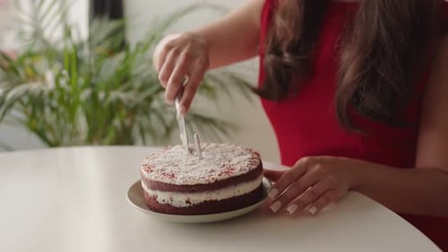 Woman Cutting Red Velvet Cake at a Table