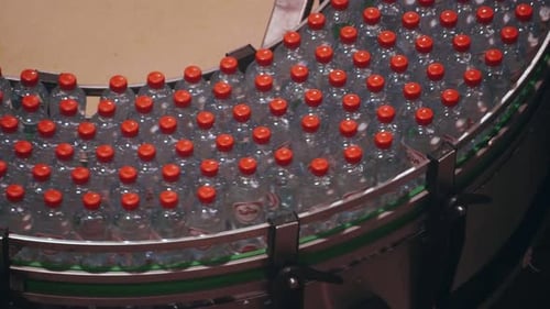 Flow of Hydration: Plastic Water Bottles Progressing on Factory Conveyor Belt