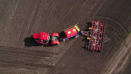 Tractor with a Seeder in an Agricultural Field Aerial View