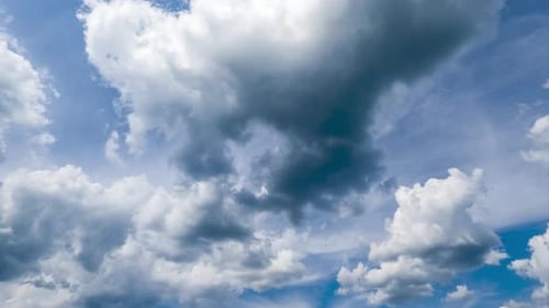 Fluffy clouds transforming at the backdrop of dense cloudscape. Cumulus clouds and spindrift clouds