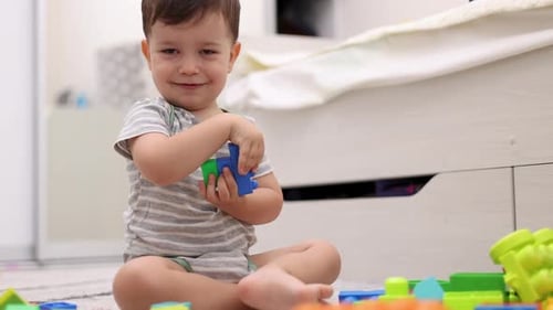 Cute Toddler Plays with Colorful Plastic Blocks
