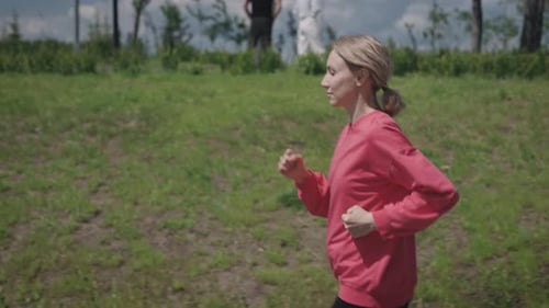 Athletic Young Woman Runs Through a Beautiful City Park Cardio Workout Outdoors in the Summer Season