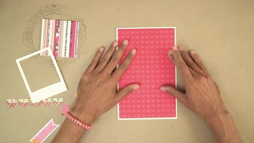 Hands Making a Card on Table