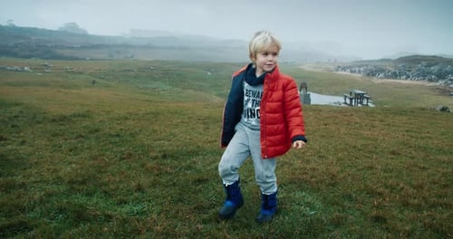 Carefree Child Run on Mountain Meadow at Vacation Travel in Slow Motion