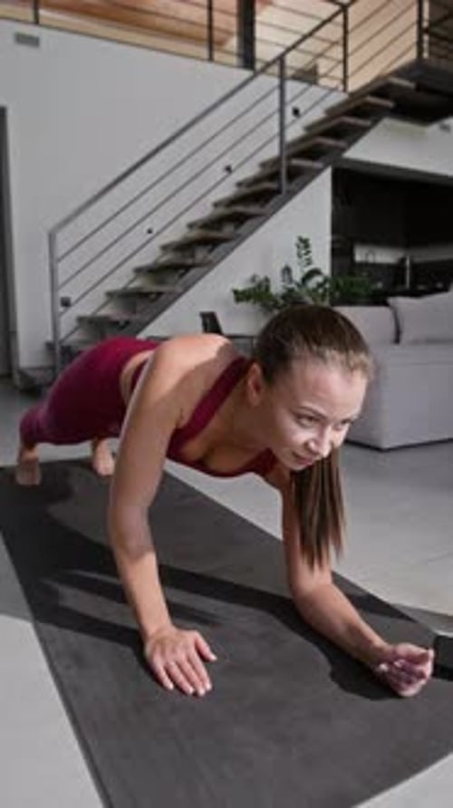 Woman Doing Plank Exercise on Mat at Home