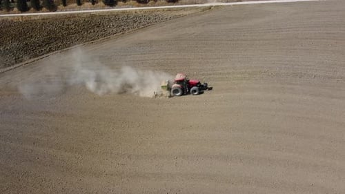 Tractor plowing ground rural agriculture field aerial view in Pienza, Tuscany