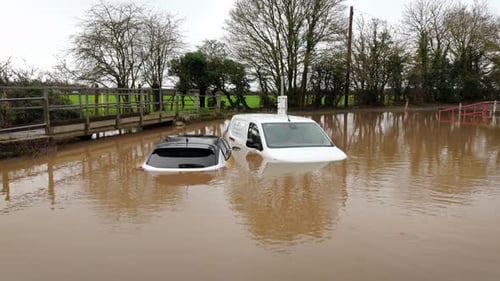 Severe Flooding Submerging Cars on a Rural Road After Heavy Rainfall Vehicles Partially Underwater